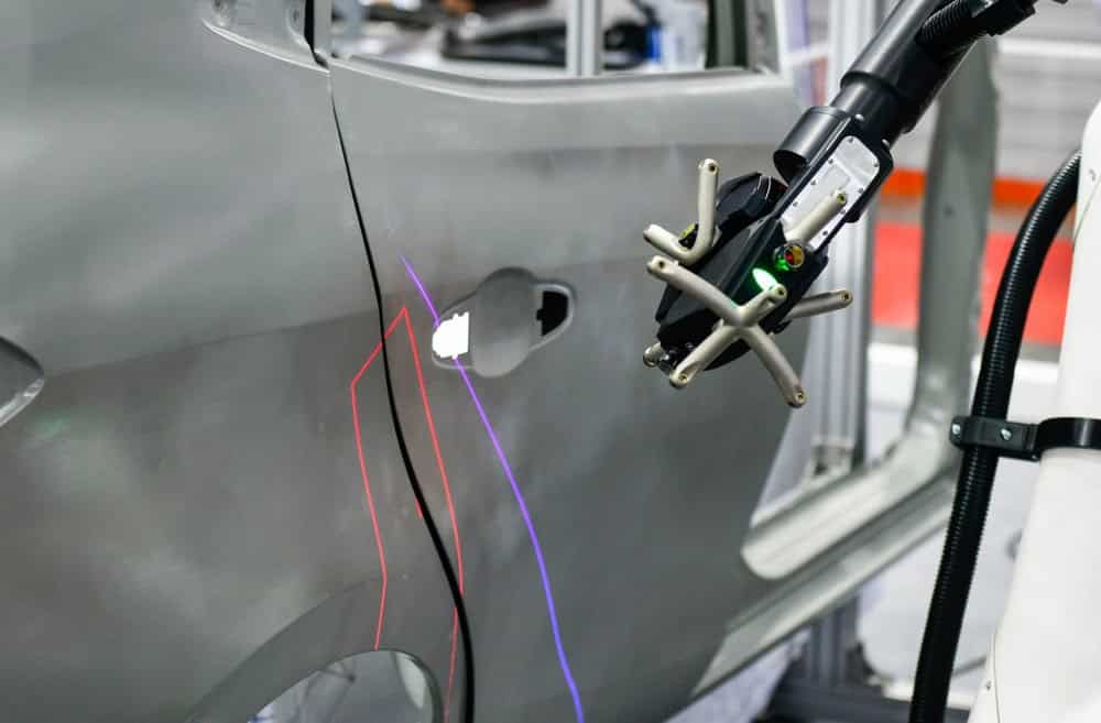 an electric 3D measuring system assesses damage on a gray car door