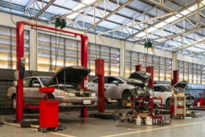 Cars in a auto repair garage. Universal auto body jigs streamline working with different car models.