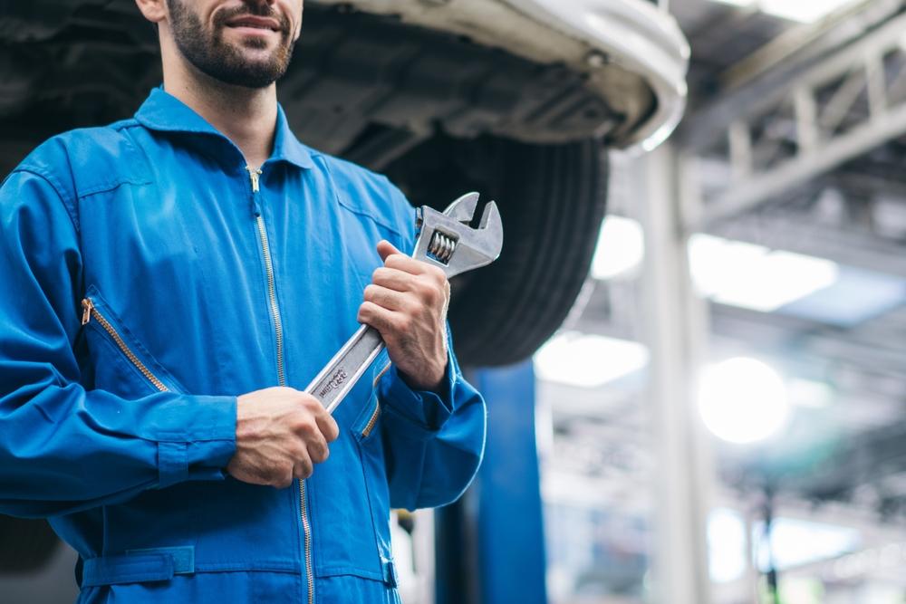 Auto repair technician with tools preparing for unibody frame repair work