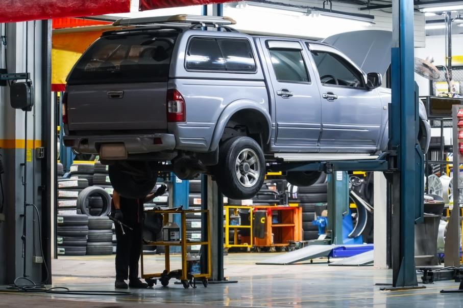 A pickup truck lifted to inspect the underbody during frame repair.
