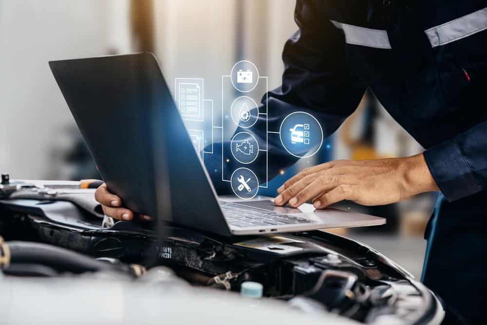 Ein Autoreparaturfachbetriebsleiter überprüft Reparaturen mithilfe einer KI-gestützten Software für Autoreparaturen.
