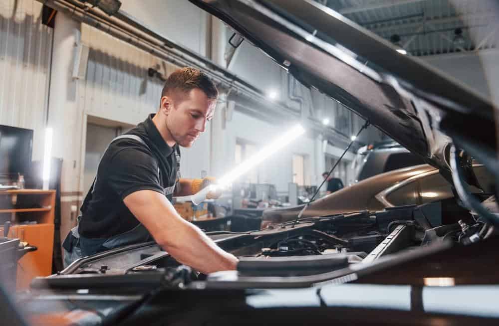 Ein Mechaniker, der an Autoreparaturen arbeitet. Die Reparatur der Rahmen- und Schienenelemente erfordert die richtigen Werkzeuge.